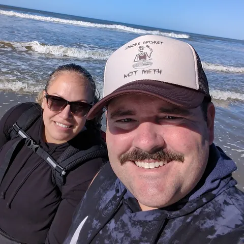 Thomas and his wife Kailee smiling in a selfie on the beach